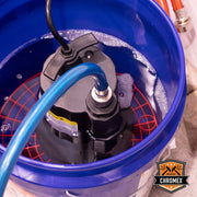 Chromex flush kit submersible pump in action inside bucket with blue hose for tankless heater descaling